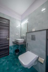 Zenith Hotels Hebbal Bangalore في بانغالور: حمام به مرحاض أبيض ومغسلة