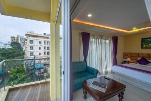 Zenith Hotels Hebbal Bangalore في بانغالور: غرفه فندقيه بسرير وشرفه