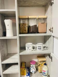 a kitchen pantry with jars of food and mugs at Gracehomes in Herrenberg