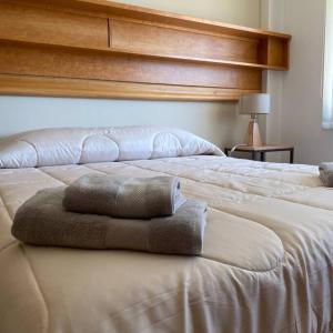 Una cama blanca con dos almohadas encima. en Hermoso y amplio departamento de categoria en San Carlos de Bariloche