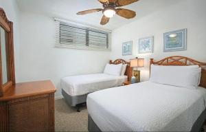 a bedroom with two beds and a ceiling fan at Unobstructed ocean views, Oceanside Pool, 2B/2B, Sleeps 6 in Kailua-Kona