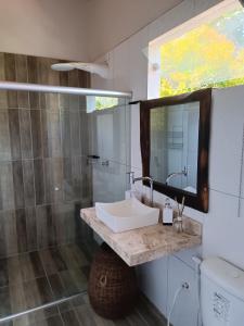 a bathroom with a sink and a shower and a mirror at Casa da Colina in Trancoso +6 photos