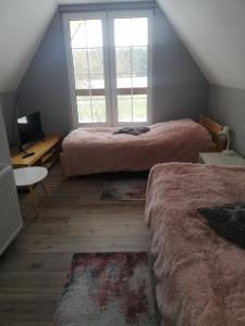 a attic bedroom with two beds and a window at Chata Nova in Milejczyce