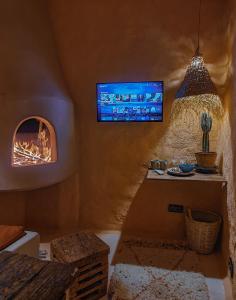 een woonkamer met een tv en een open haard bij Casa Amina in Chefchaouene