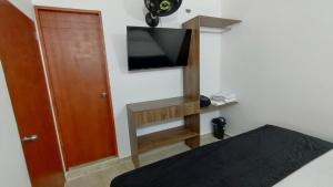 um quarto com uma cama e uma televisão na parede em Hotel Boutique Estadio em Medellín