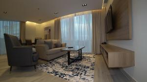 Villa Misk Alkhobar في الخبر: غرفة معيشة بها أريكة وطاولة وتلفزيون