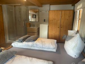 a bedroom with two beds and a shower at Branderhof in Jochberg