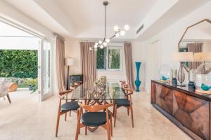 a dining room with a glass table and chairs at Majestic Golf View 4BR Villa at Punta Cana Resort in Punta Cana