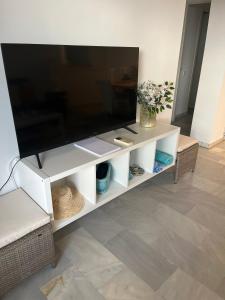 einen Flachbild-TV auf einem weißen Entertainment-Center in der Unterkunft Estrelicia III in Marbella