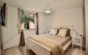 Bett in einem Zimmer mit einem Fenster und einem Bett sidx sidx sidx sidx in der Unterkunft Pavillon Lilly in Menton