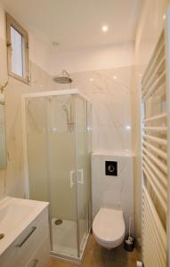 a bathroom with a toilet and a glass shower at Pavillon Lilly in Menton