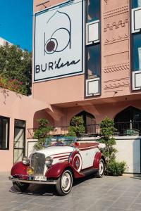 an old red and white car parked in front of a building at Bur'Dera - a Boutique Luxury Hotel in Jaipur