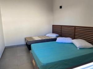 2 Einzelbetten in einem Zimmer mit gedankenlosem, gedankenlosem, gedankenlosem, gedankenlosem in der Unterkunft Cantinho Aconchegante 2 in Brotas