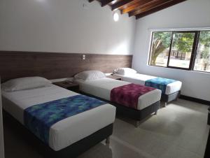 a bedroom with two beds and a window at Hotel Boutique Estadio in Medellín