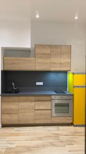 een keuken met houten kasten en een gele koelkast bij Appartement proche de la mer in La Garde