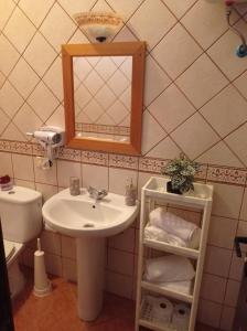 a bathroom with a sink and a mirror and a toilet at Apartamento La Punta in Alojera