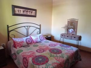 um quarto com uma cama com uma colcha floral e um espelho em Apartamento La Punta em Alojera