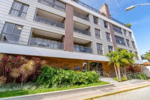 un edificio de apartamentos con plantas delante en Porto Madero, Condo com Piscina e Academia -Apto 3 dorms 7 pessoas- Centro de Bombinhas, en Bombinhas