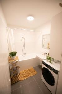 ein Badezimmer mit einer Badewanne, einem Waschbecken und einem Herd in der Unterkunft Schönes Living am Donauufer in Wien