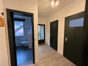 a hallway with a bathroom with a toilet and a door at Platell Ferienhäuser Lerbach in Lerbach