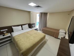 Habitación de hotel con cama y TV en Flat beira mar Tambaú, en João Pessoa