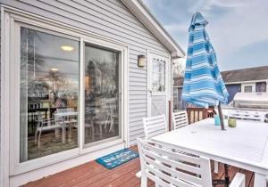 un patio con una mesa blanca y sillas en una terraza en Walk to the Beach! Large beach house, en Middletown