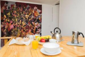 a table with a plate of food and a tea kettle at LX Townhouse Ideal for Big Groups. Prime Location Top Street in Lisbon