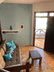ein Wohnzimmer mit einem Sofa und blauen Kissen in der Unterkunft Paraiso de Maracajau in Maracajaú