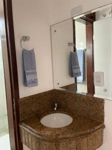 a bathroom with a sink and a mirror at Paraiso de Maracajau in Maracajaú
