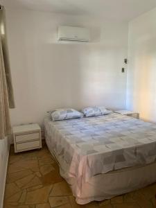 a bedroom with a bed with two pillows on it at Paraiso de Maracajau in Maracajaú