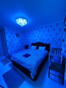 a bedroom with a bed and a blue light at BLUE MOON HOMESTAY in Bobigny