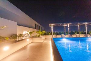a swimming pool on the roof of a house at night at Accra Luxury Apartments @ The Lennox in Accra