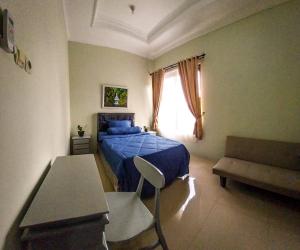 Un dormitorio con una cama azul y una ventana en Gated 3BR Residence - 10 mins from Malioboro en Yogyakarta