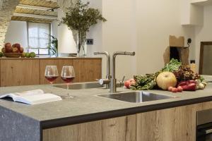 eine Küche mit Spüle und 2 Gläsern Wein in der Unterkunft Turisme Rural Mas Ametller - Casa Gran in Fontclara