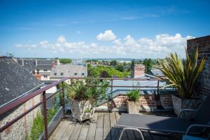 a balcony with plants and a view of a city at Logis Saint-Léonard in Honfleur
