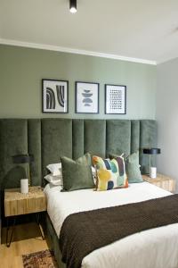 Schlafzimmer mit einem großen Bett mit einem grünen Kopfteil in der Unterkunft Executive Apartment at Ellipse Waterfall in Midrand
