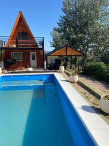 uma piscina azul em frente a uma casa em Alpina La Luna em Valle Hermoso