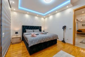 een slaapkamer met een bed met een blauw licht erop bij Apartman Elena Gold Zlatibor in Zlatibor