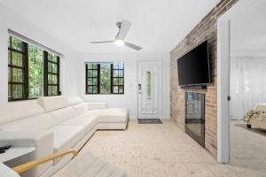 a living room with a white couch and a brick wall at Little Havana Retreat - Newly remodeled Villa by Loan Depot Stadium! in Miami