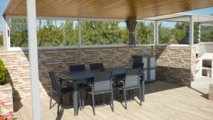 un patio con mesa negra y sillas en Logement fantastique avec vue imprenable, en Macisbenda