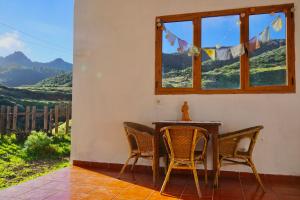 uma mesa e cadeiras num quarto com uma janela em La Casita em Vega de San Mateo