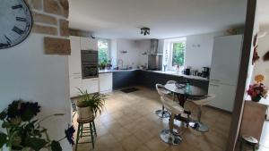 une cuisine avec une table, des chaises et une horloge murale dans l'établissement Maison Dream in Marciac, à Marciac