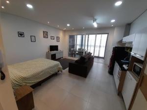 1 dormitorio con 1 cama y sala de estar en JK STUDIO Xavante com Garagem, en Pelotas