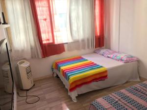 Un dormitorio con una cama con una manta de colores. en Apartamento no Centro Histórico de Salvador, en Salvador