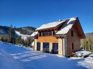 una baita di tronchi nella neve con neve di Hillview Jasná Chalet a Demänovská Dolina