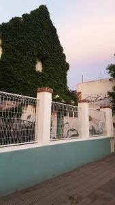 una valla blanca con hiedra en el lateral de un edificio en Hostel Cultural Casa Taller en Bahía Blanca