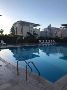a swimming pool with chairs and blue water at villaLemoon in Belek