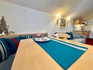 a living room with a table and a couch at Appartements Die Bergretter in Ramsau am Dachstein
