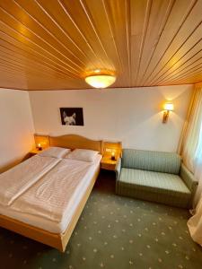 a hotel room with a bed and a couch at Appartements Die Bergretter in Ramsau am Dachstein