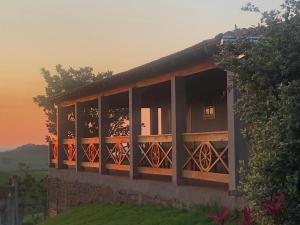 a house with windows with a sunset in the background at Pousada Villa Paraizo in Ribeirão Claro